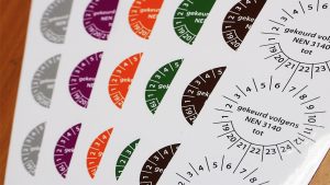 Meerdere stroken NEN 3140 keuringsstickers in verschillende kleuren